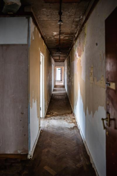 looking down a long corridor in a scruffy dilapidated office building