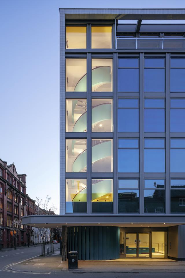 exterior view of hilton house, glass window building at dusk