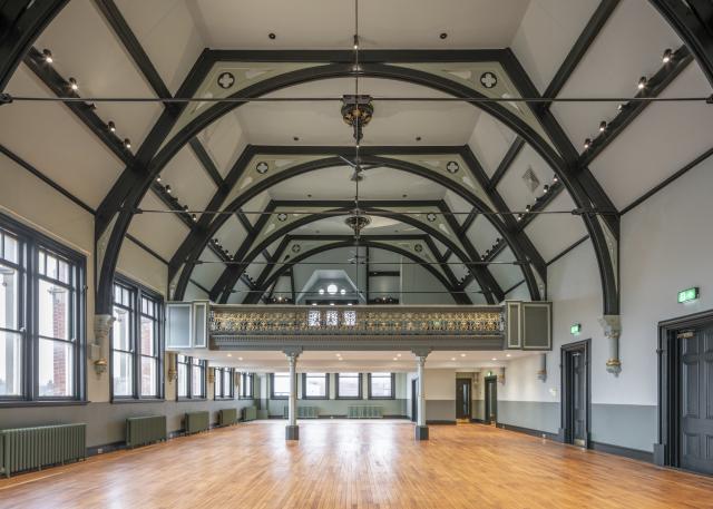 interior of stretford public hall, high ceilings, forest green beams, polished wooden floors