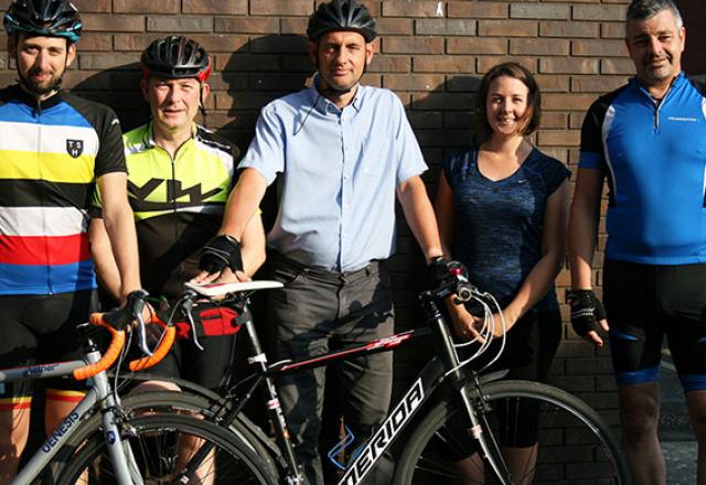 group of staff cyclists posing outside of studio