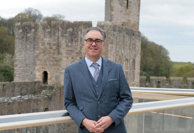 Chris Wilson standing against railings at Caernarfon Castle